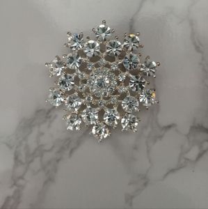 Decorative starburst or snowflake crystal brooch or pin